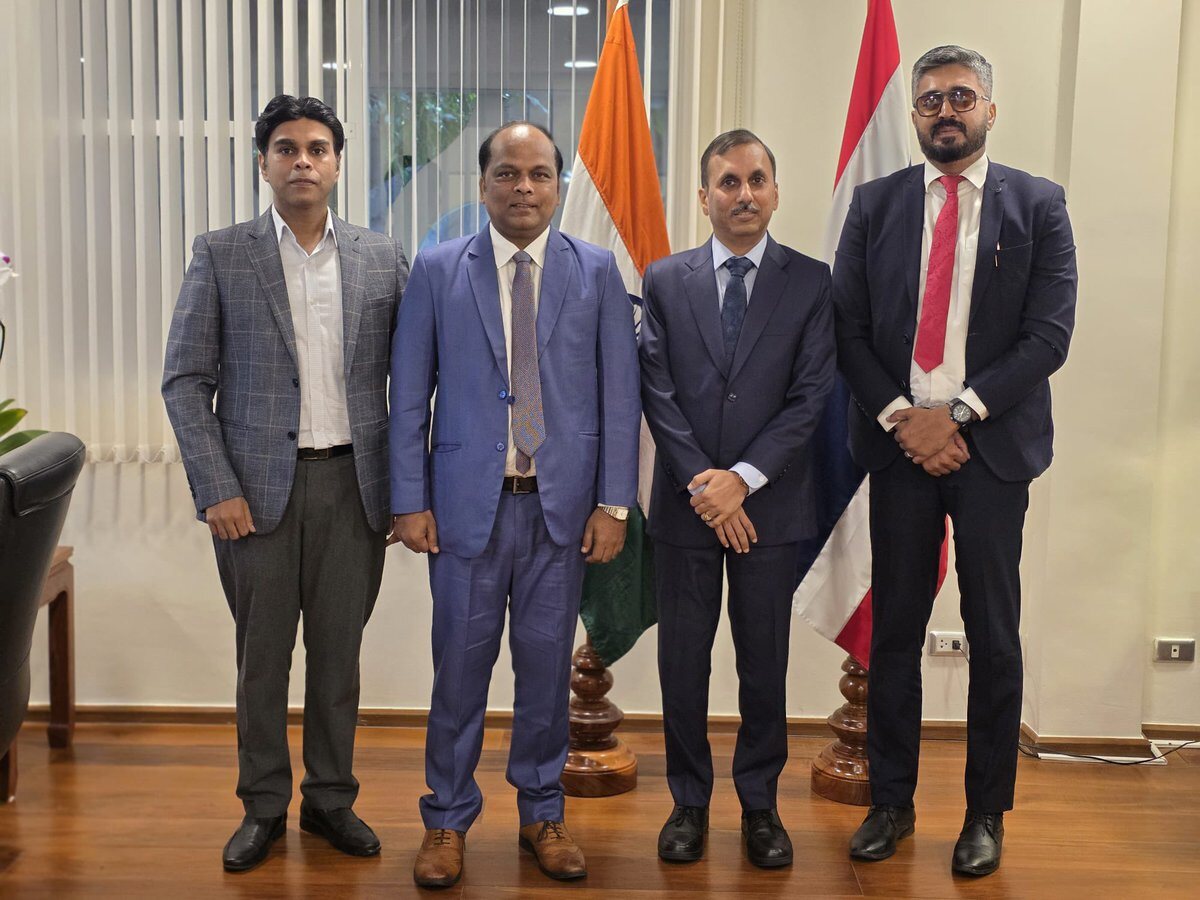 Rahul Laxman Patil with delegation colleagues at a diplomatic mission, standing between the Indian flag and a partner nation's flag.