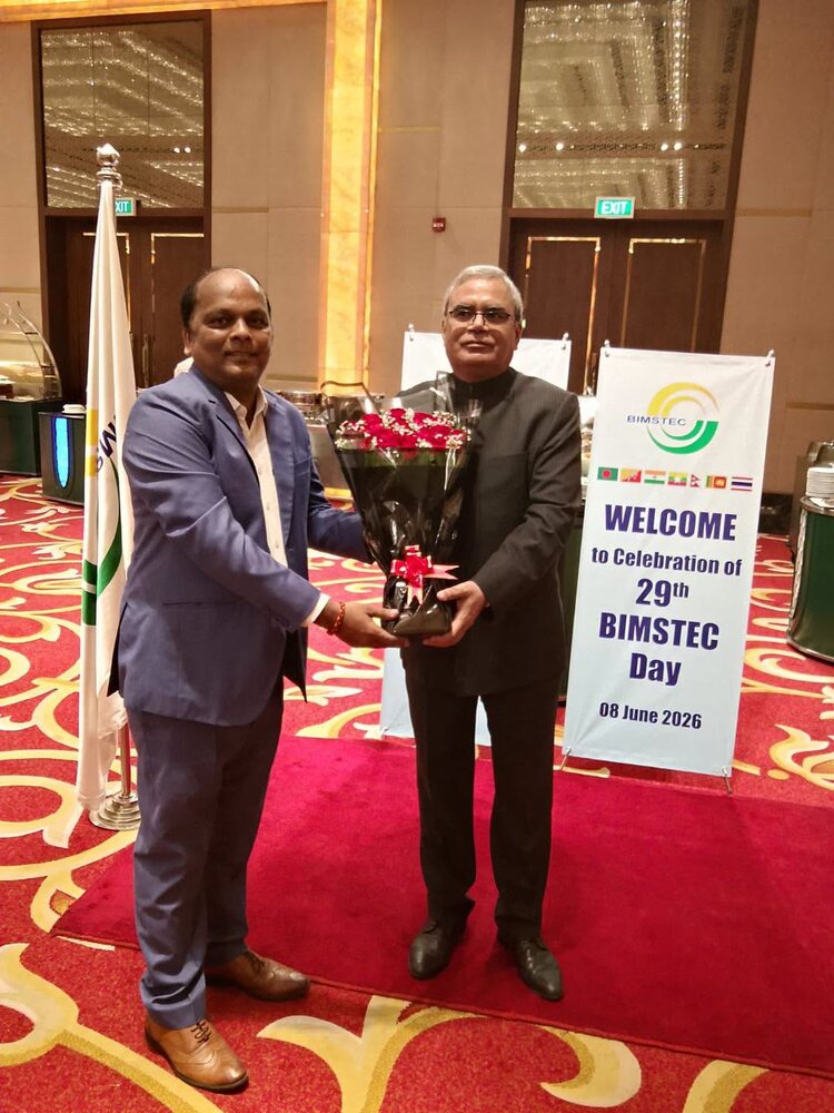 Rahul Laxman Patil presenting a bouquet at the 29th BIMSTEC Day celebration, with the BIMSTEC banner and member-state flags visible behind.